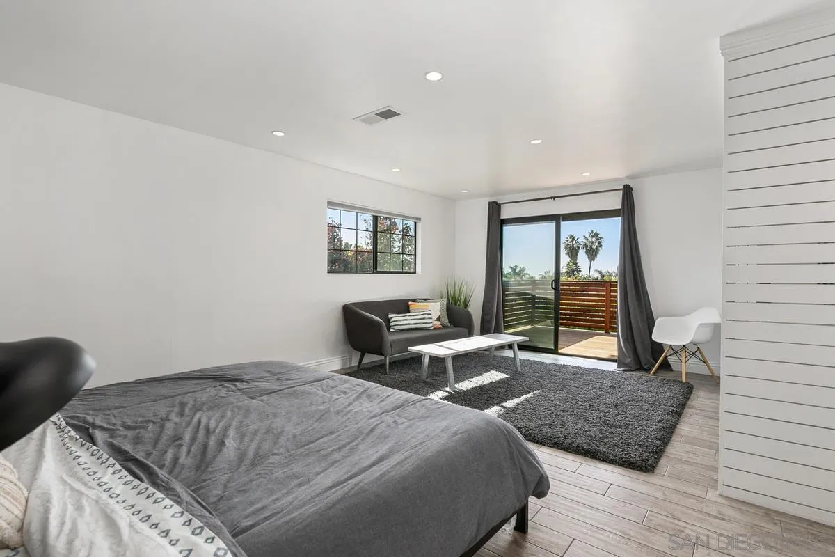970 Saxony Road Encinitas, CA 92024 - Photo 16 of 39 a bedroom with a bed and wooden floor