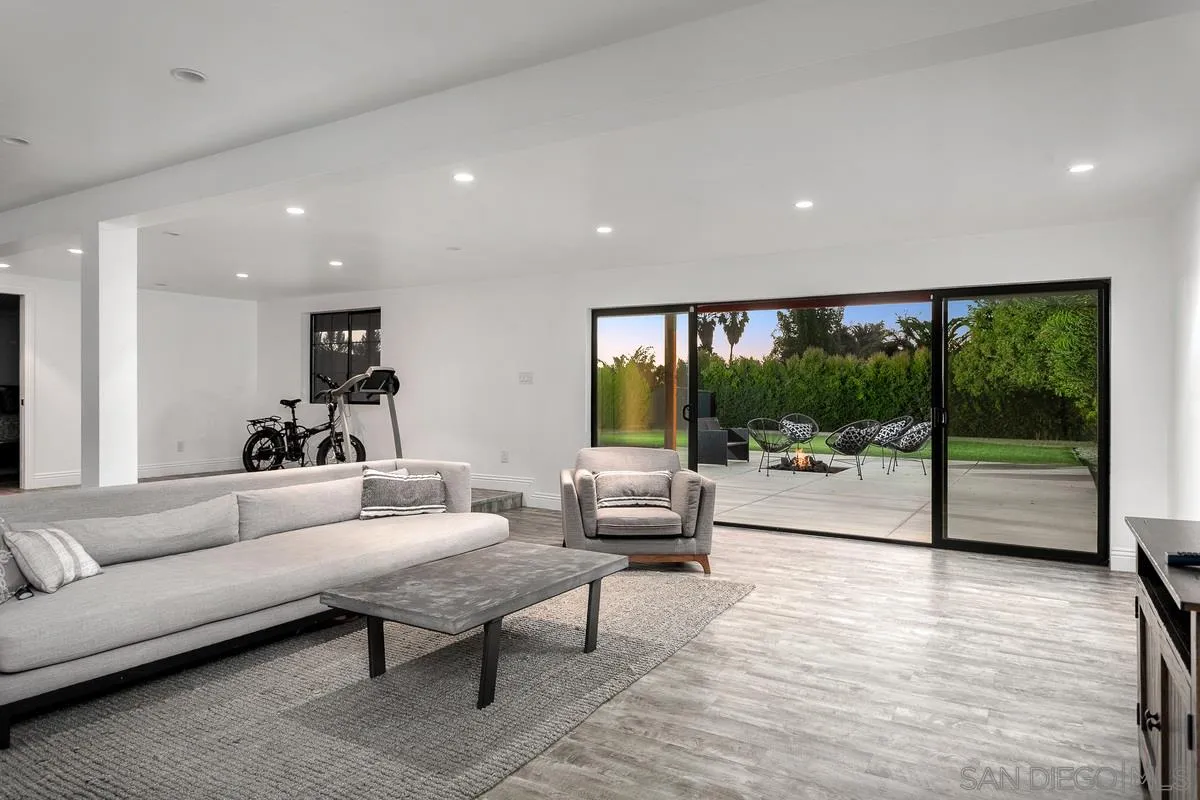 970 Saxony Road Encinitas, CA 92024 - Photo 17 of 39 a living room with furniture floor to ceiling window and a table