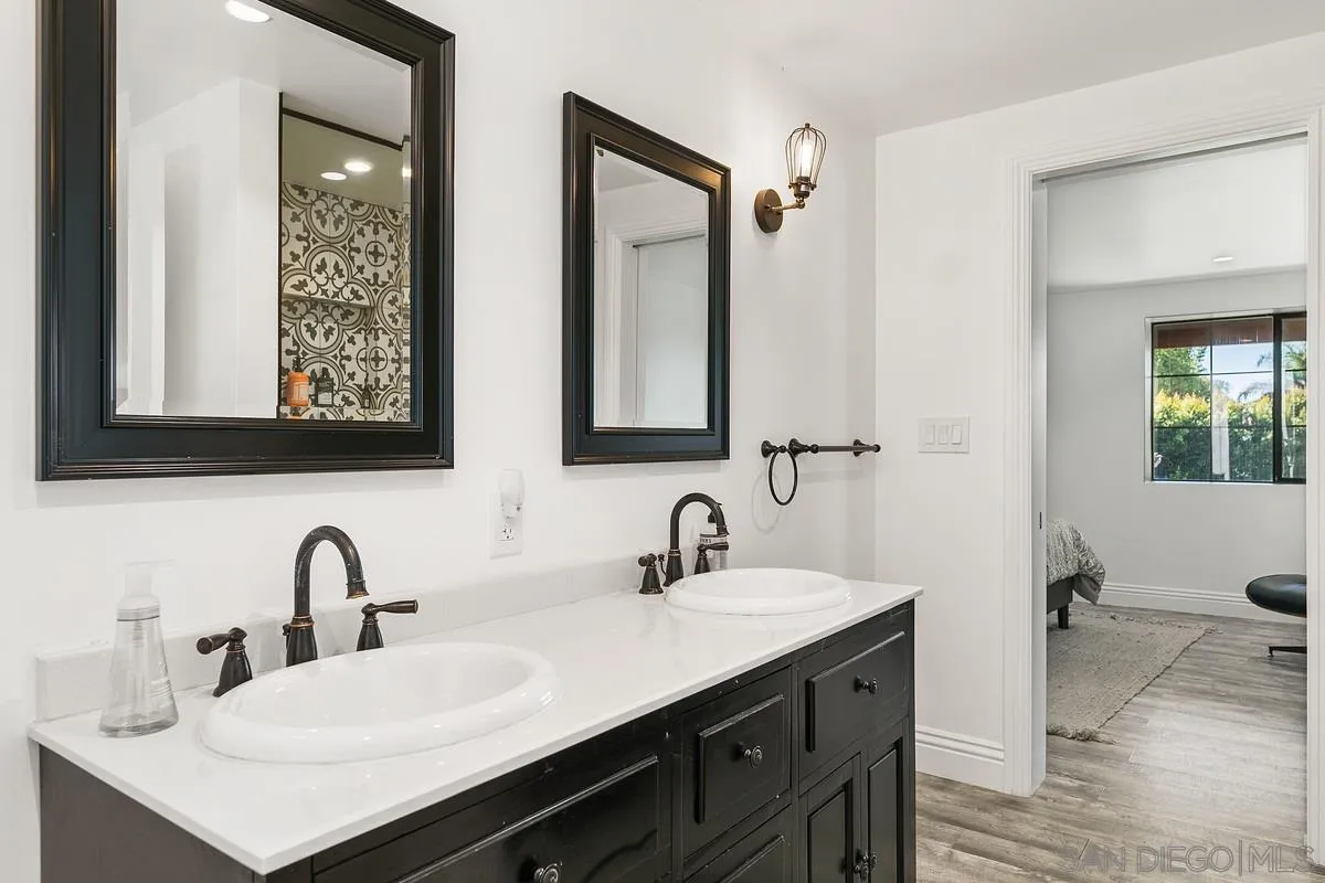 970 Saxony Road Encinitas, CA 92024 - Photo 22 of 39 a bathroom with double vanity sinks and a mirror