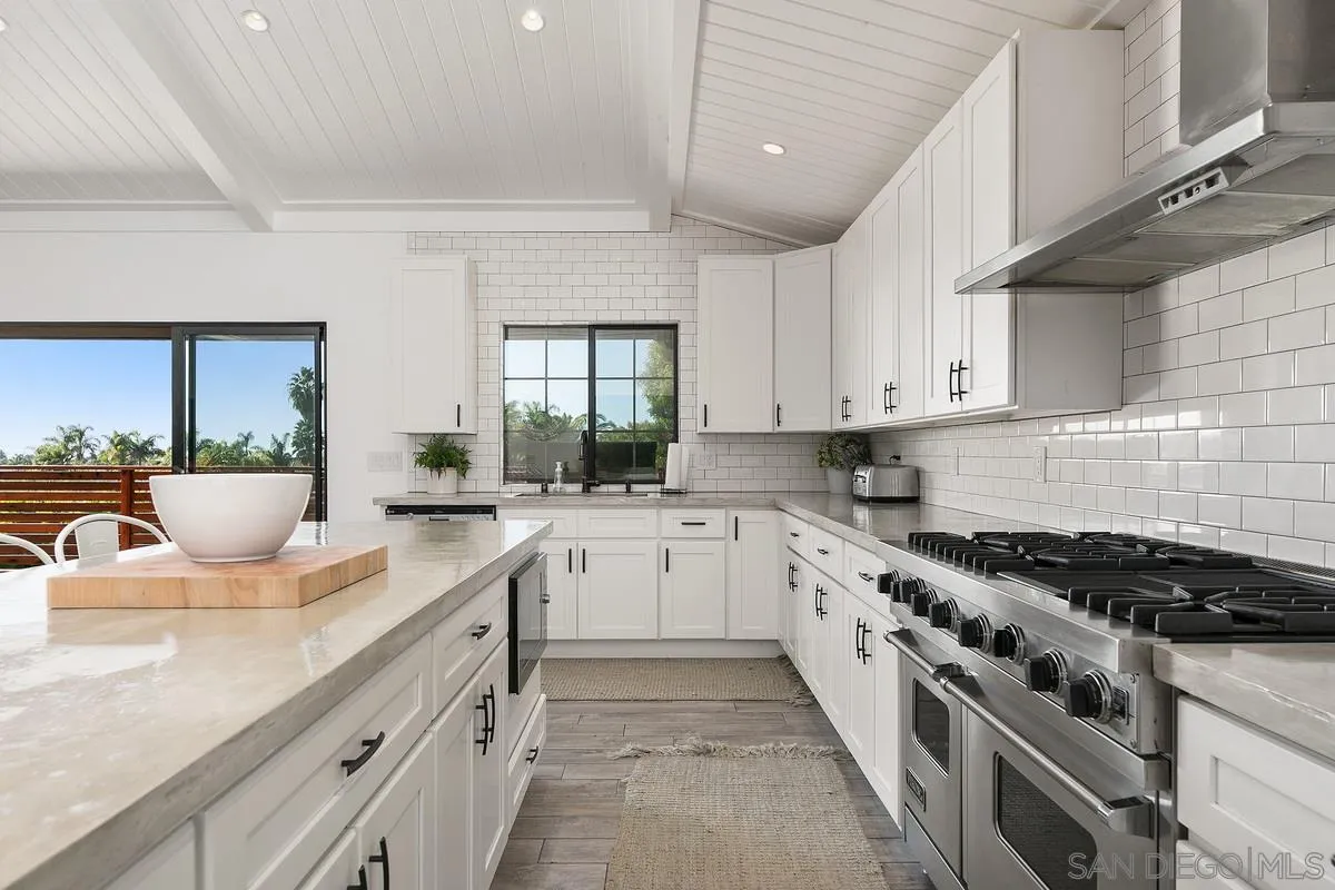 970 Saxony Road Encinitas, CA 92024 - Photo 10 of 39 a kitchen with kitchen island granite countertop lots of counter top space a sink and appliances
