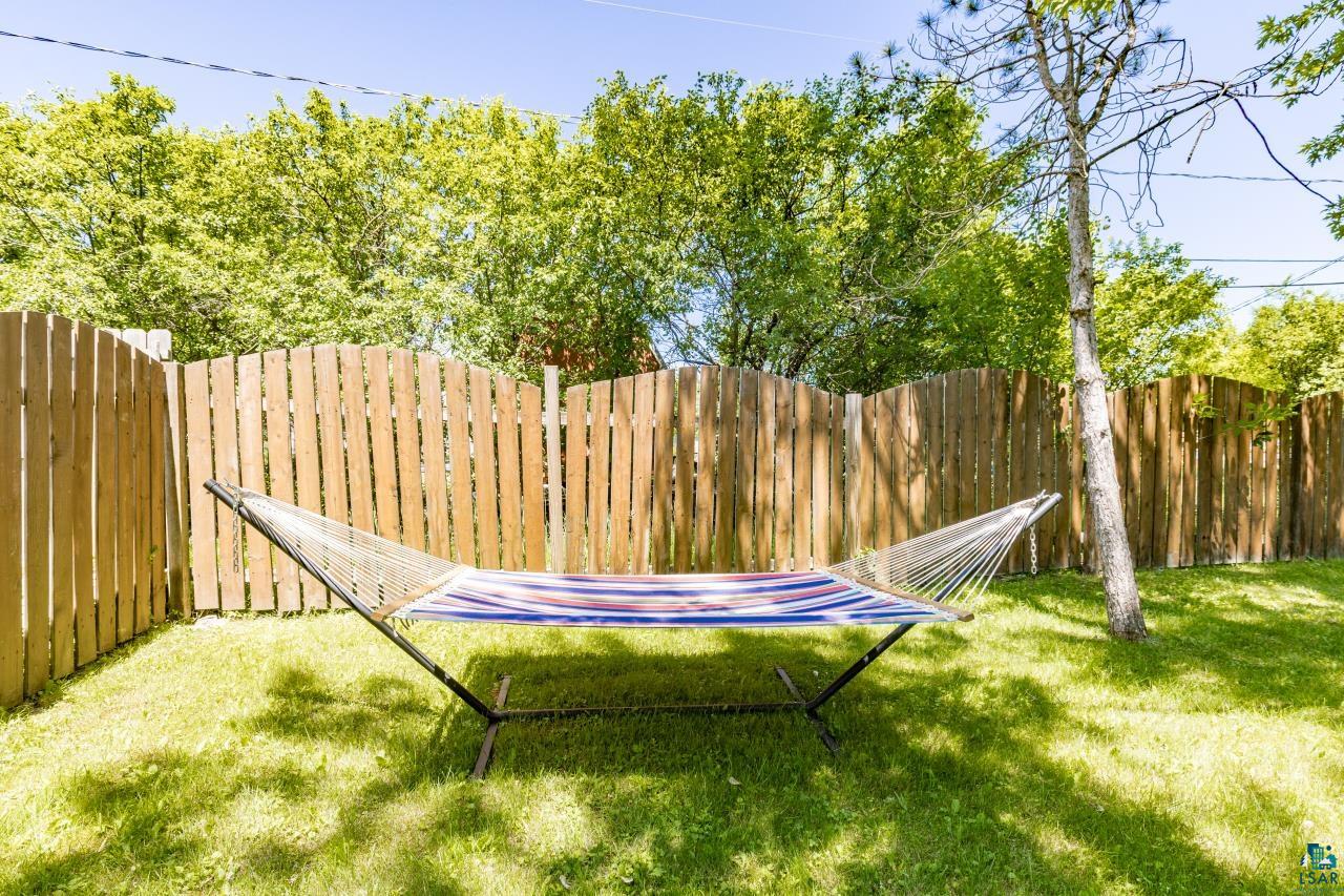 4119 Pitt Street Duluth, MN 55804 - Photo 25 of 50 Private backyard featuring a wooden fence, mature trees, and a grassy lawn