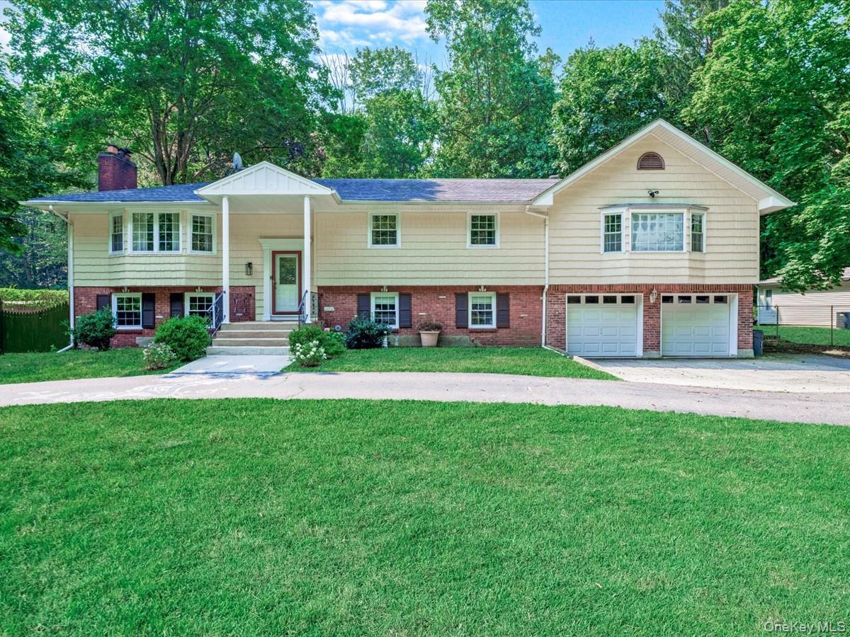 a front view of a house with a yard and green space