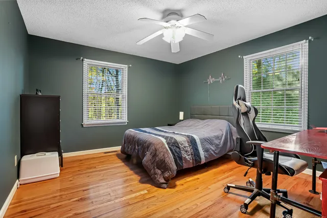 a bedroom with a bed and wooden floor