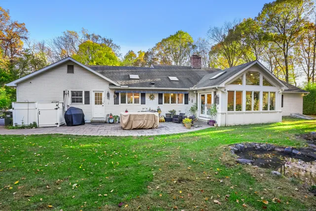 a front view of a house with a garden and trees