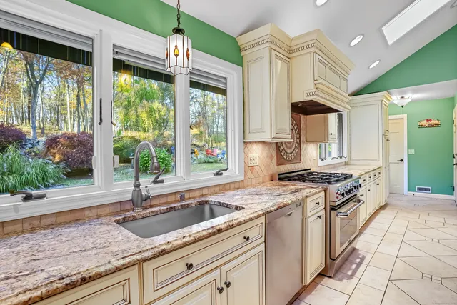a kitchen with granite countertop a sink a counter top space and cabinets