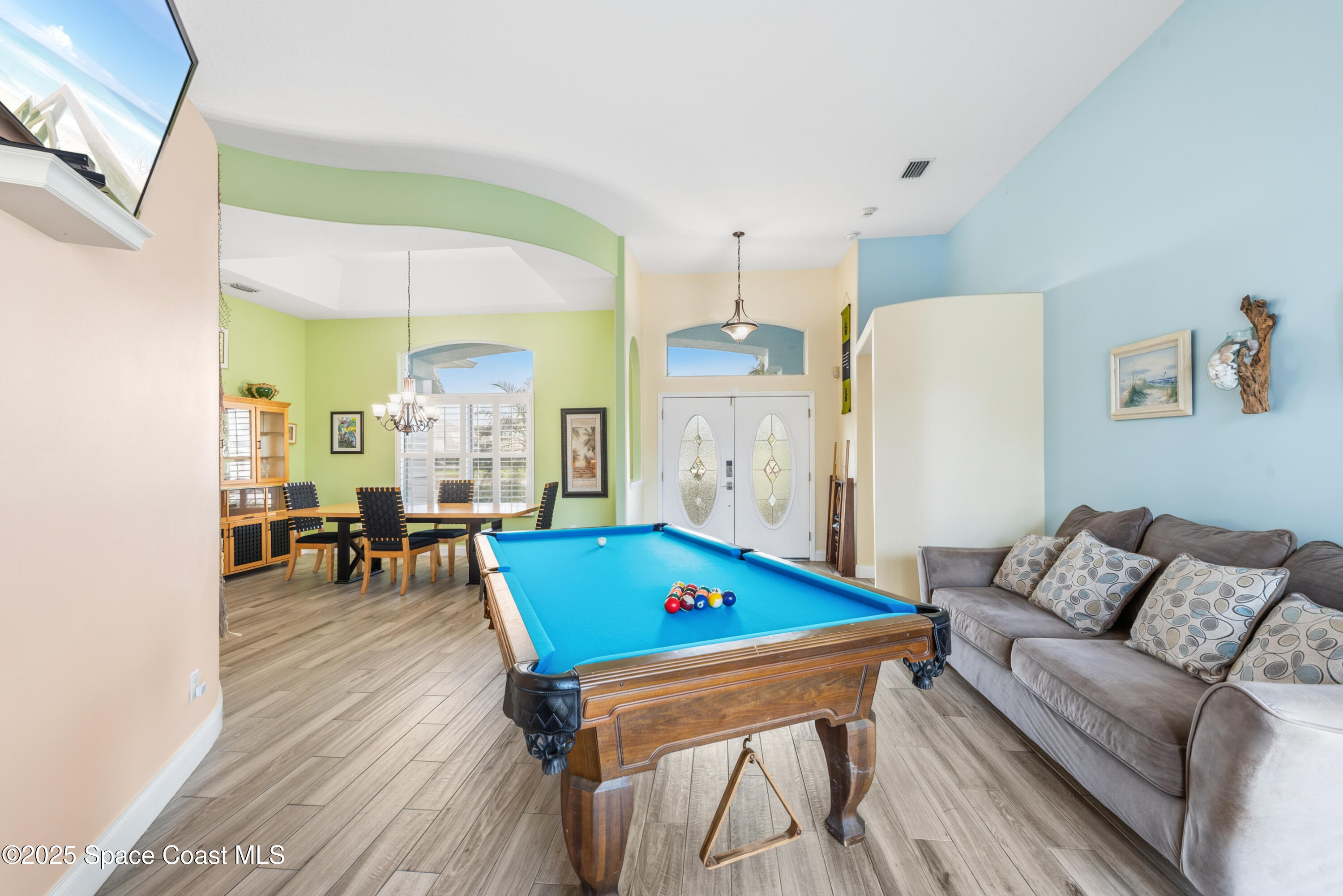 452 Veracruz Boulevard Indialantic, FL 32903 - Photo 11 of 42 a living room with furniture and a dining table with wooden floor