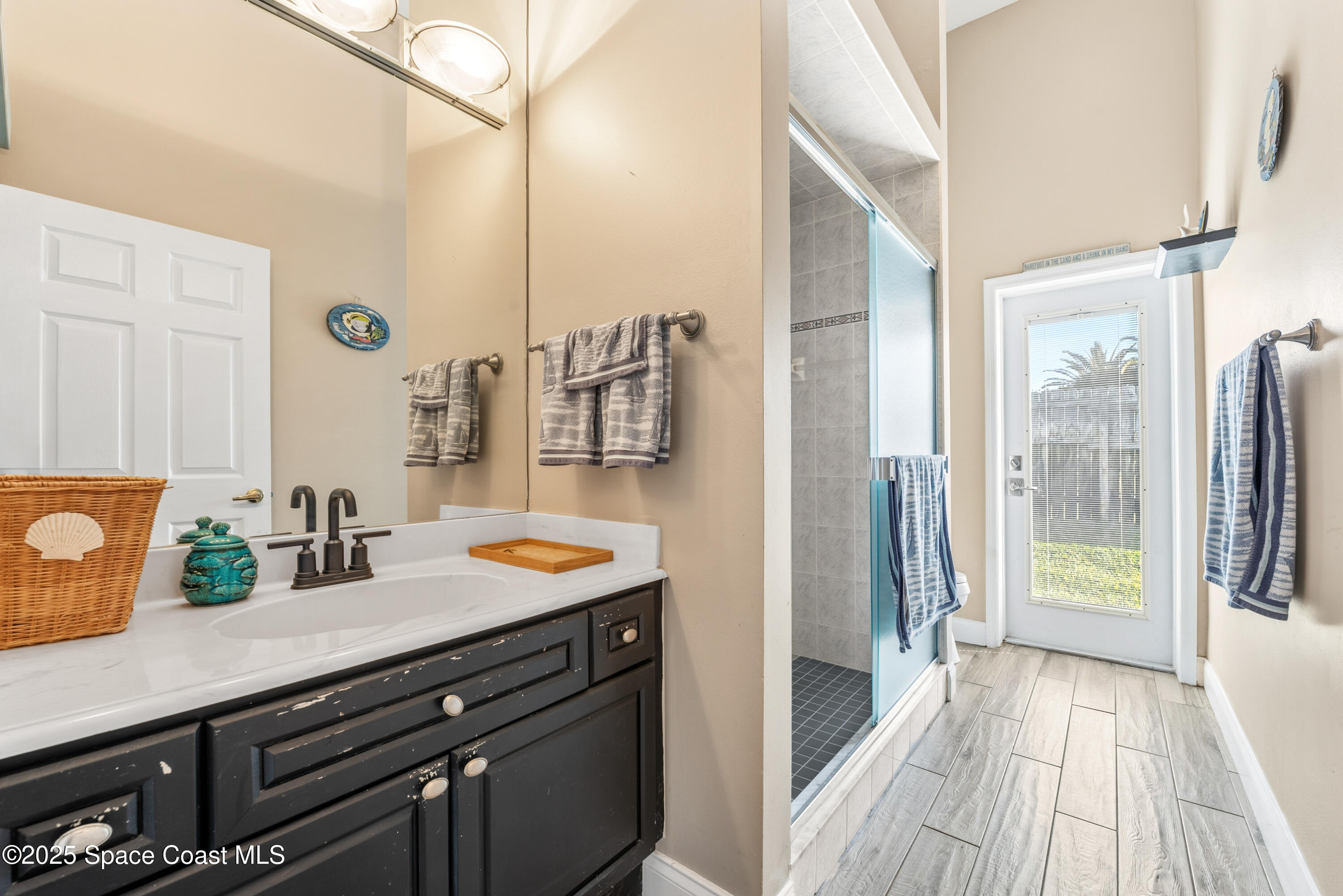 452 Veracruz Boulevard Indialantic, FL 32903 - Photo 22 of 42 a bathroom with a granite countertop sink a mirror and shower