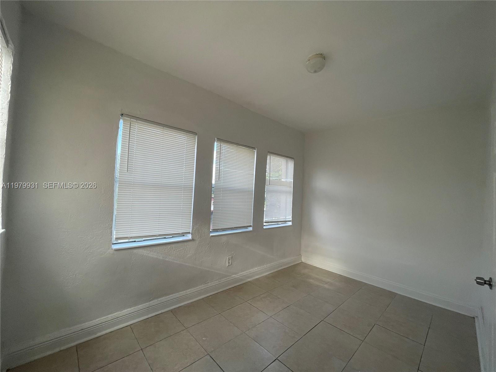 1060 Northwest 47th Street, Unit 5 Miami, FL 33127 - Photo 12 of 19 an empty room with windows and closet