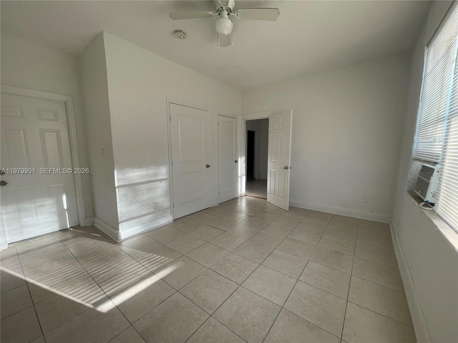 1060 Northwest 47th Street, Unit 5 Miami, FL 33127 - Photo 13 of 19 an empty room with windows and entrance