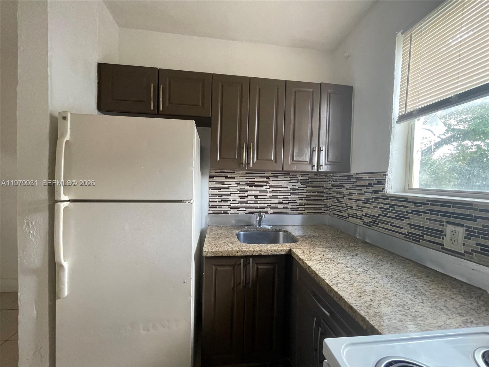 1060 Northwest 47th Street, Unit 5 Miami, FL 33127 - Photo 5 of 19 a white refrigerator freezer sitting inside of a kitchen