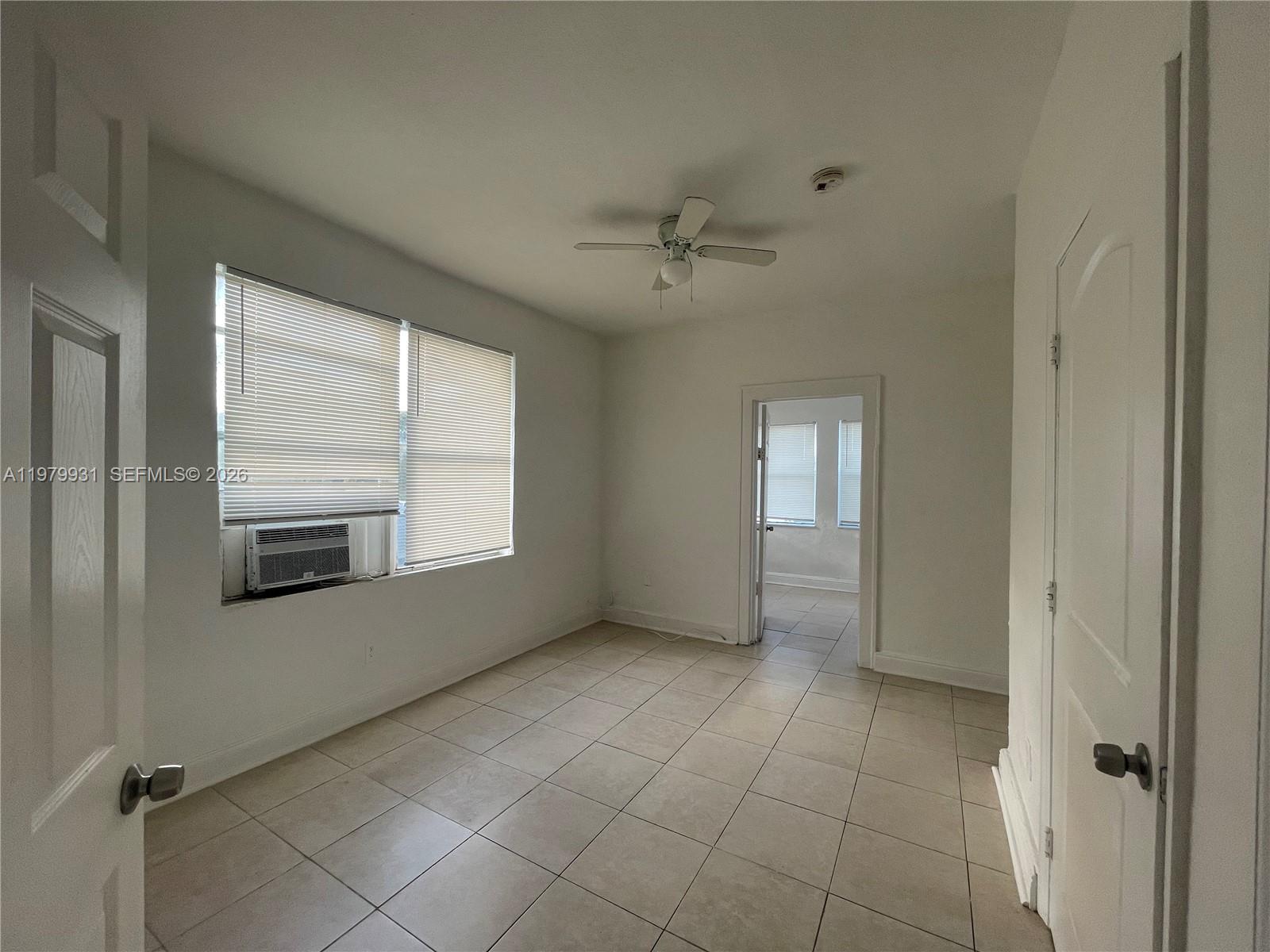 1060 Northwest 47th Street, Unit 5 Miami, FL 33127 - Photo 8 of 19 a view of an empty room with a window and a kitchen