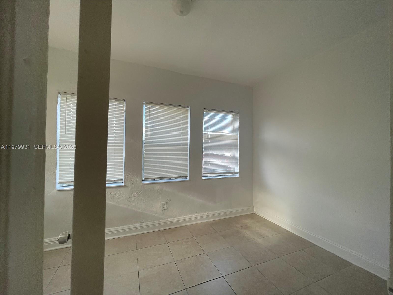 1060 Northwest 47th Street, Unit 5 Miami, FL 33127 - Photo 10 of 19 a view of an empty room and window