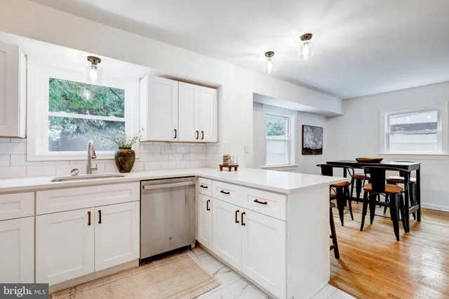 a kitchen with white cabinets and sink