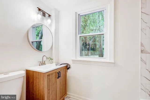 a bathroom with a sink a mirror and a window