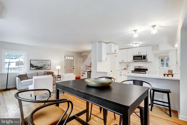 a kitchen with a table chairs stove and white kitchen