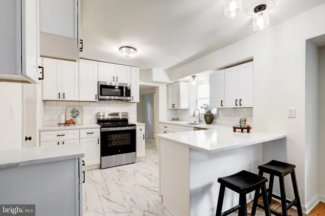 a kitchen with kitchen island a stove a sink dishwasher and a refrigerator with wooden cabinets