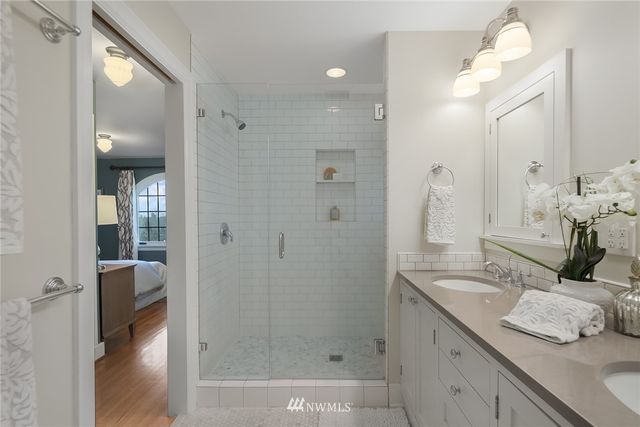 a bathroom with a double vanity sink mirror and shower