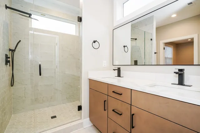 a bathroom with a shower sink and mirror
