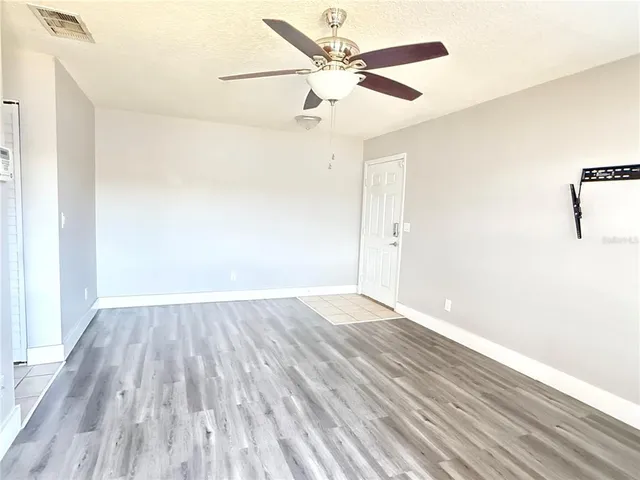 a view of an empty room with wooden floor