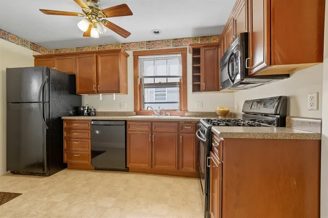 a kitchen with stainless steel appliances granite countertop a refrigerator a stove a sink and a microwave