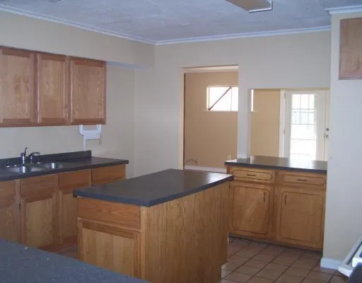 a kitchen with granite countertop a sink and white cabinets