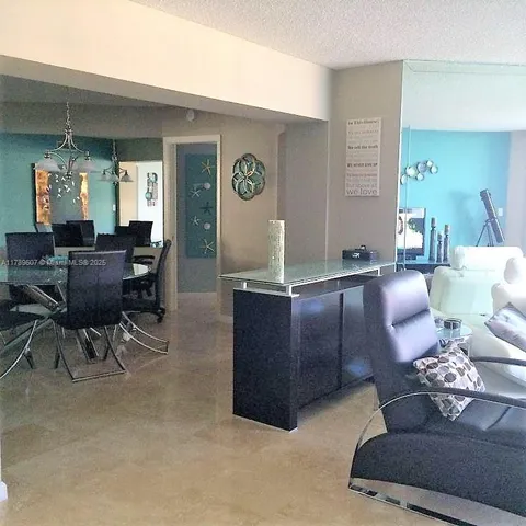 a living room with furniture flat screen tv and a large window