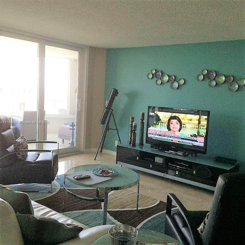 1340 South Ocean Boulevard, Unit 1003 Pompano Beach, FL 33062 - Photo 16 of 27 a living room with furniture flat screen tv and a large window