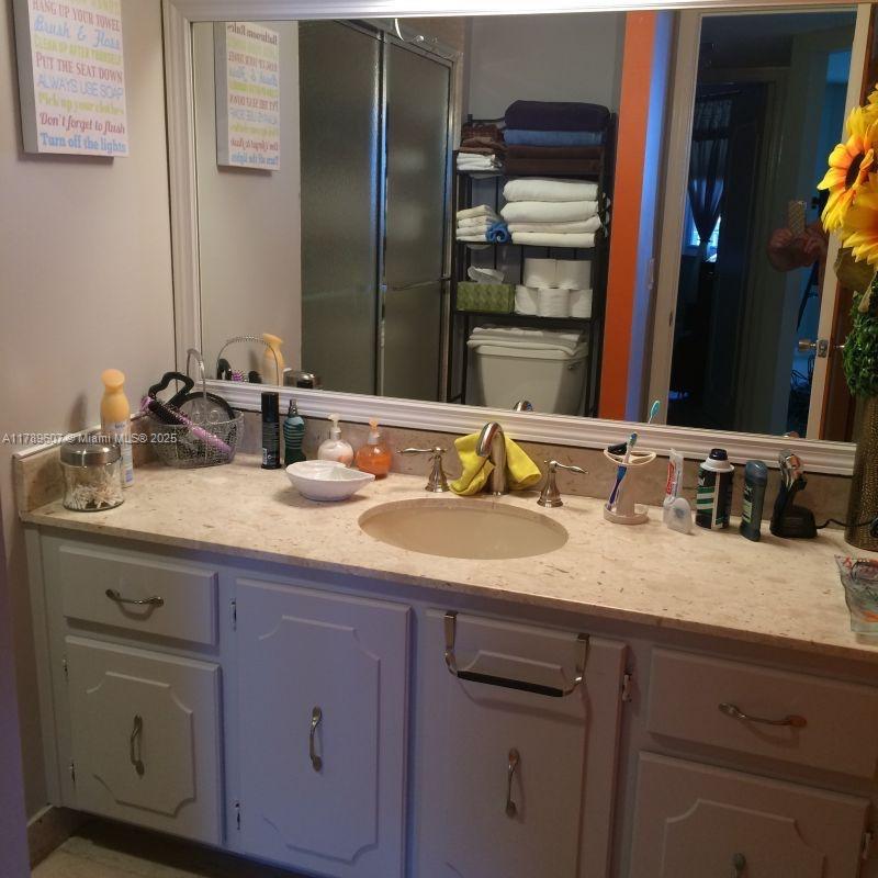 1340 South Ocean Boulevard, Unit 1003 Pompano Beach, FL 33062 - Photo 19 of 27 a bathroom with a granite countertop sink and a mirror
