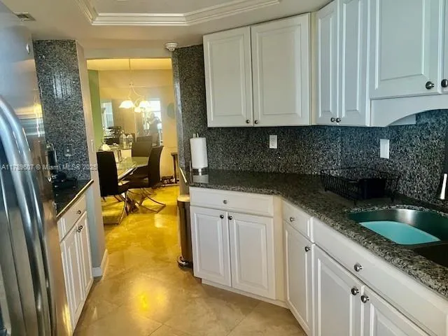 a kitchen with granite countertop a sink a stove and cabinets