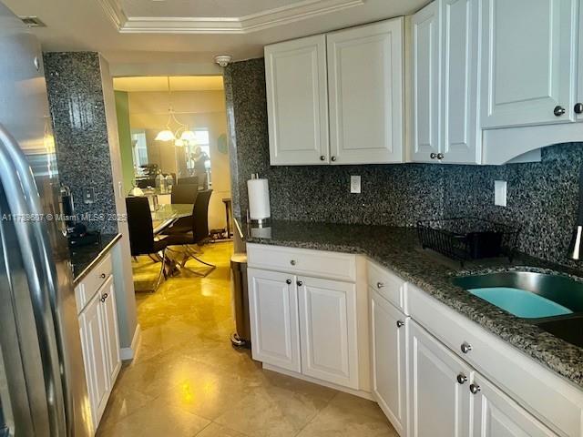 1340 South Ocean Boulevard, Unit 1003 Pompano Beach, FL 33062 - Photo 5 of 27 a kitchen with granite countertop a sink a stove and cabinets