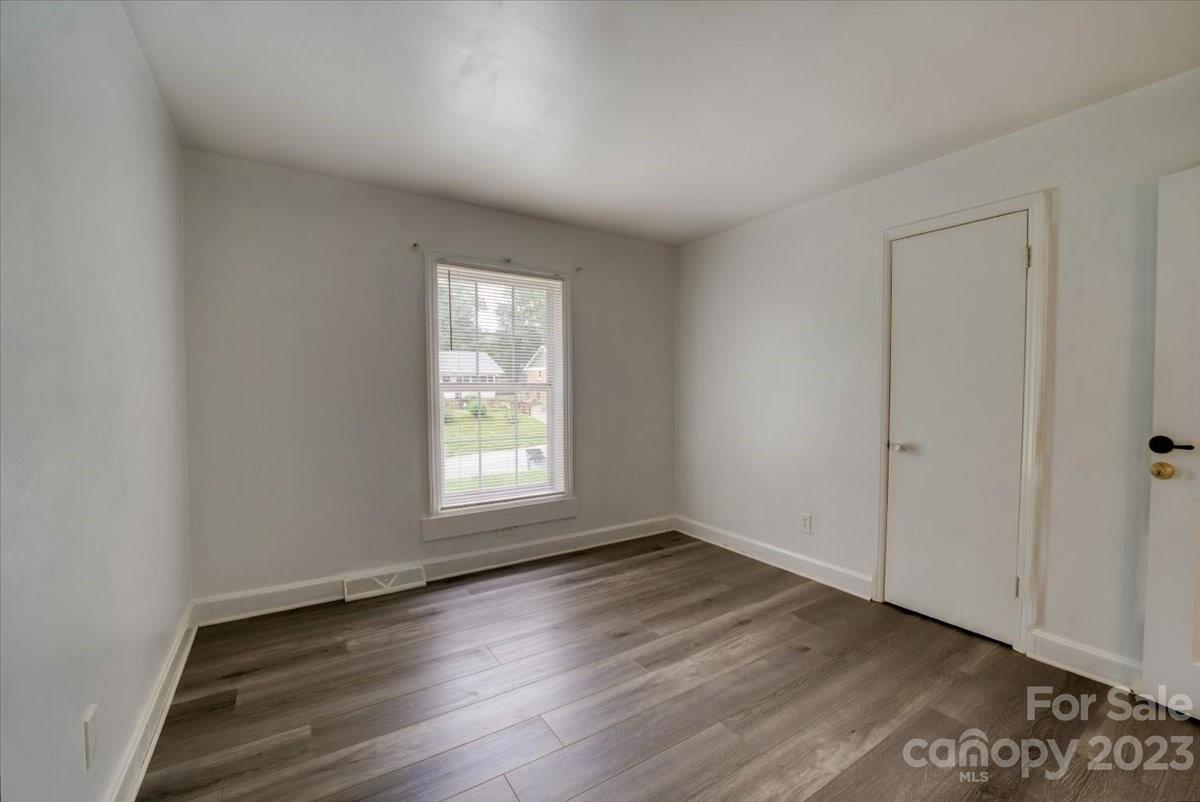 1223 Ranch Road Charlotte, NC 28208 - Photo 16 of 34 an empty room with wooden floor and windows