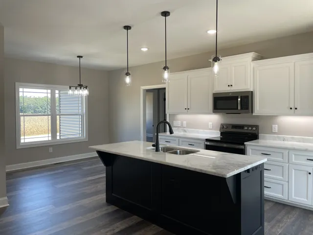 a kitchen with kitchen island a sink stainless steel appliances and window