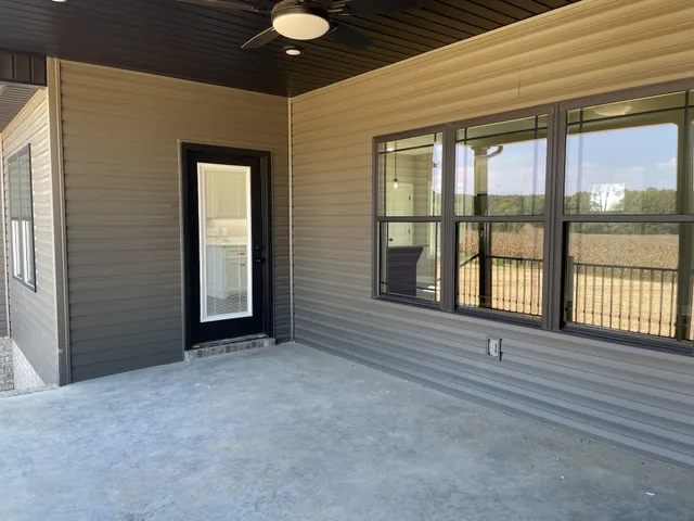 a kitchen with stainless steel appliances granite countertop a refrigerator a sink a stove and white cabinets with wooden floor