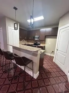 a kitchen with stainless steel appliances granite countertop a stove a sink and a refrigerator