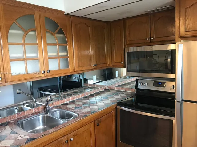 a kitchen with stainless steel appliances granite countertop a stove microwave and refrigerator