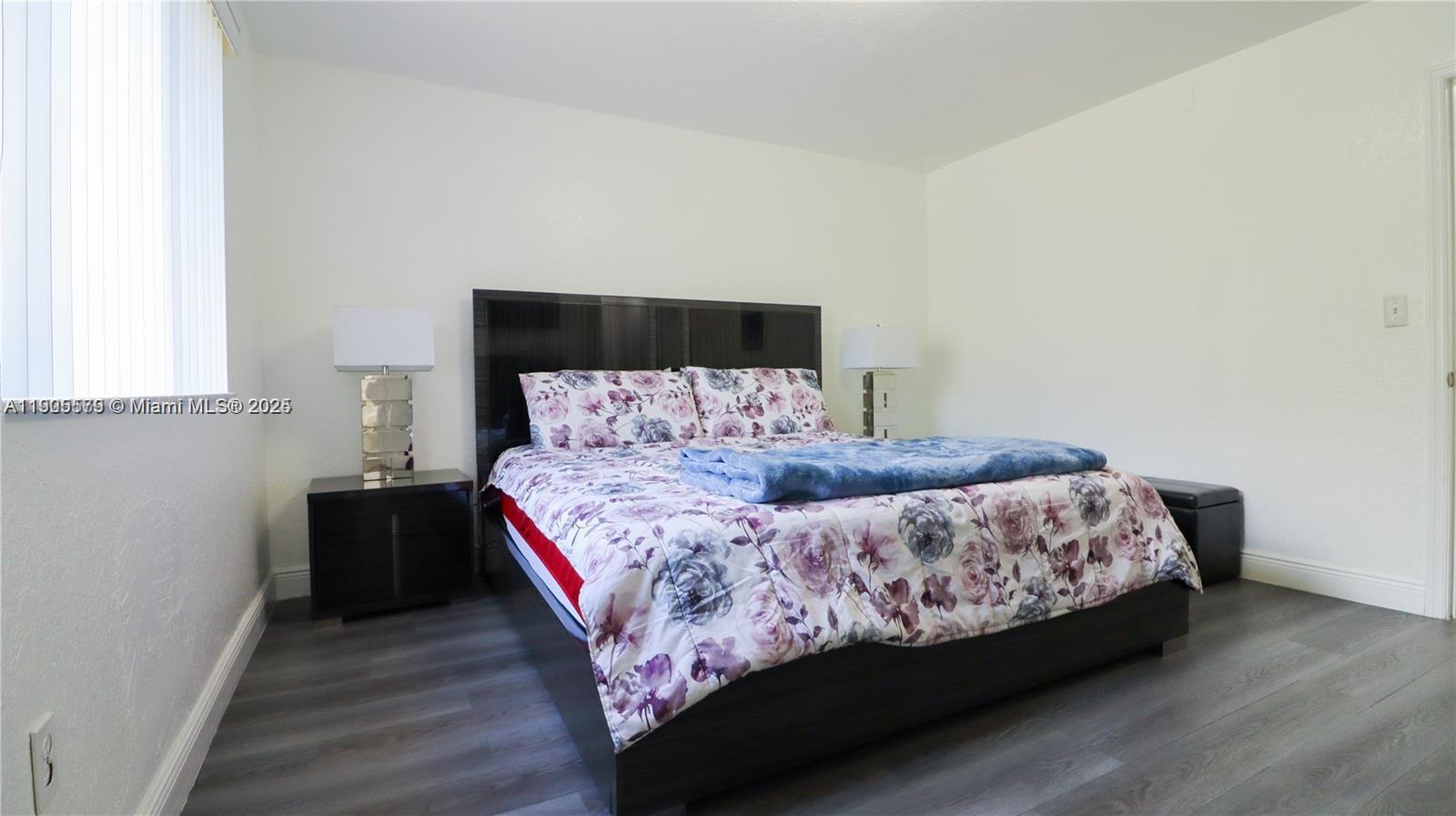 15330 Southwest 134th Place, Unit 308 Miami, FL 33177 - Photo 14 of 29 a bedroom with a bed and wooden floor