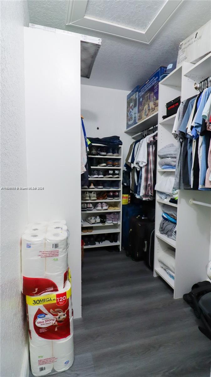 15330 Southwest 134th Place, Unit 308 Miami, FL 33177 - Photo 19 of 29 a view of walk in closet with clothes and shoes