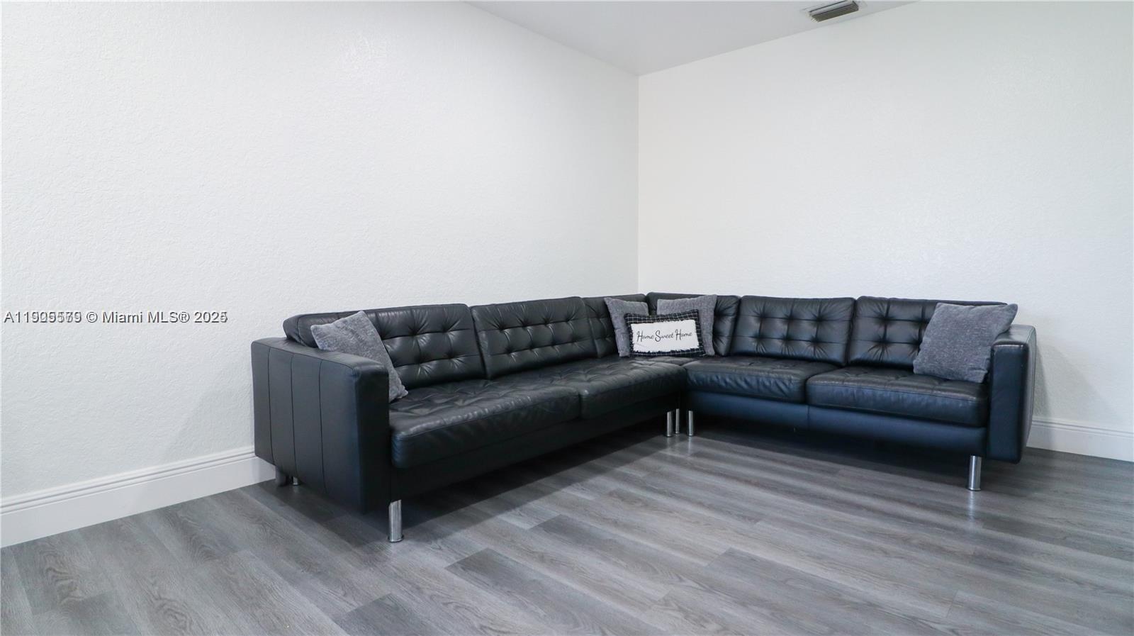 15330 Southwest 134th Place, Unit 308 Miami, FL 33177 - Photo 3 of 29 a living room with a couch and a wooden floor