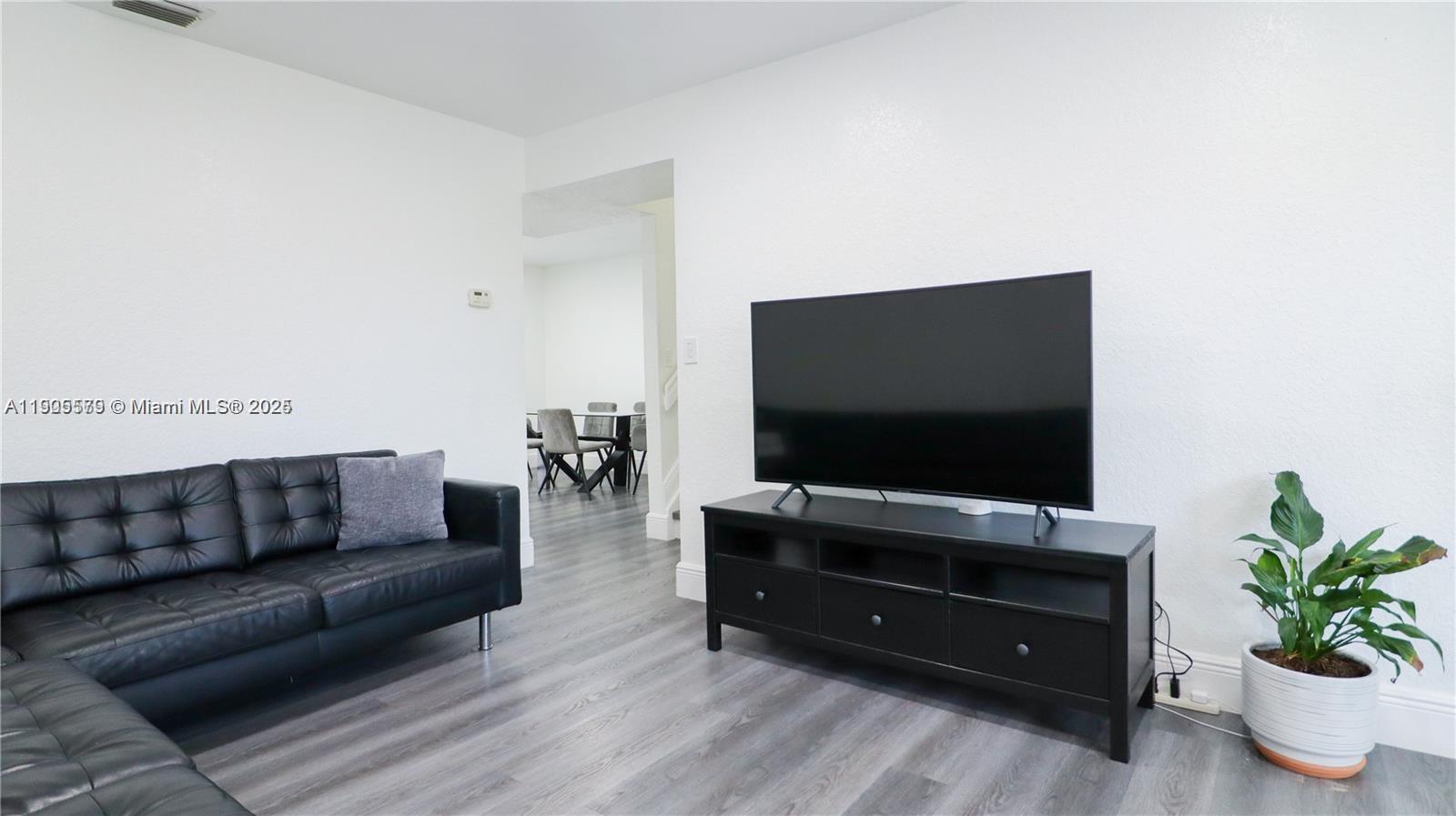 15330 Southwest 134th Place, Unit 308 Miami, FL 33177 - Photo 6 of 29 a living room with furniture and a flat screen tv