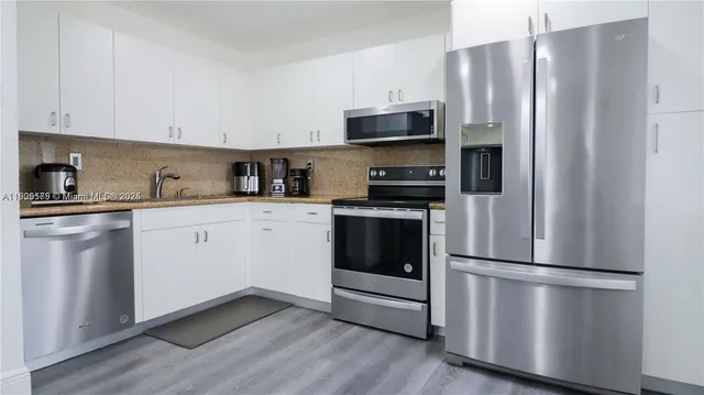 a kitchen with stainless steel appliances a refrigerator sink and microwave