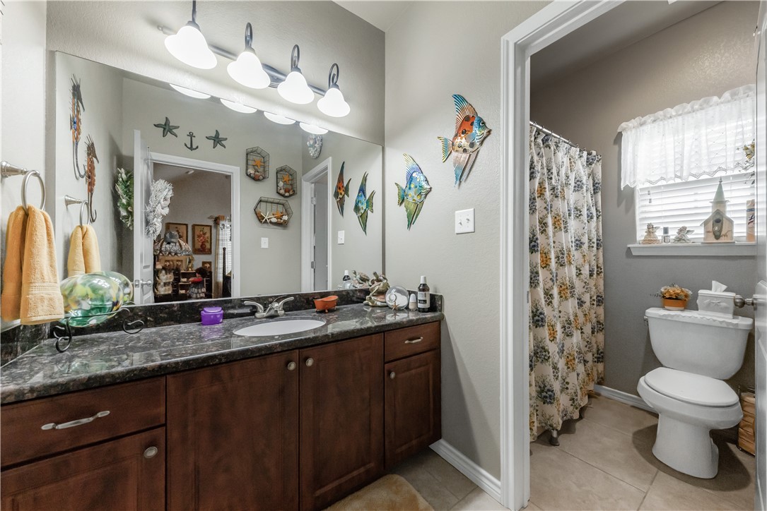 3815 Harvey Road College Station, TX 77845 - Photo 20 of 24 a bathroom with a granite countertop sink a toilet and a mirror