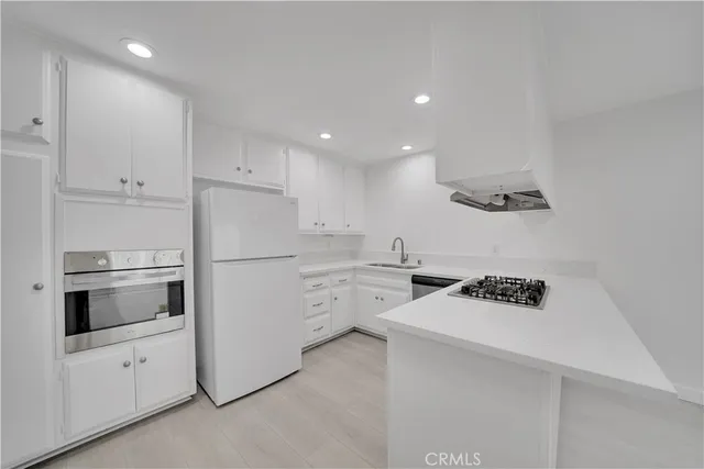 a kitchen with white cabinets and white appliances