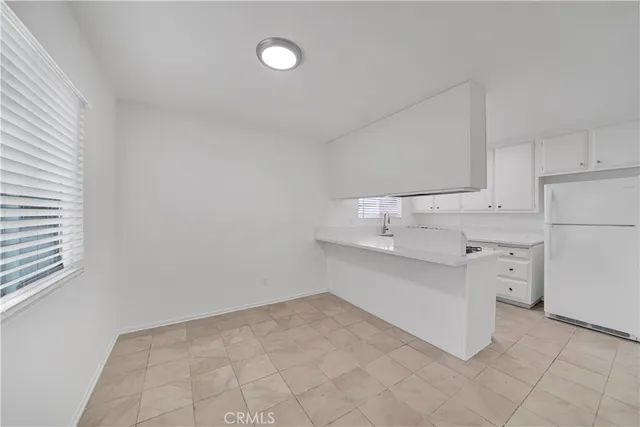 a kitchen with white cabinets and appliances