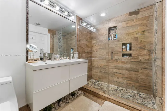 a bathroom with a sink a toilet and shower