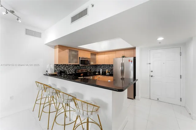 a kitchen with granite countertop a sink and stainless steel appliances