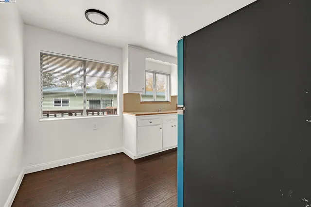 a kitchen with granite countertop white cabinets and a window