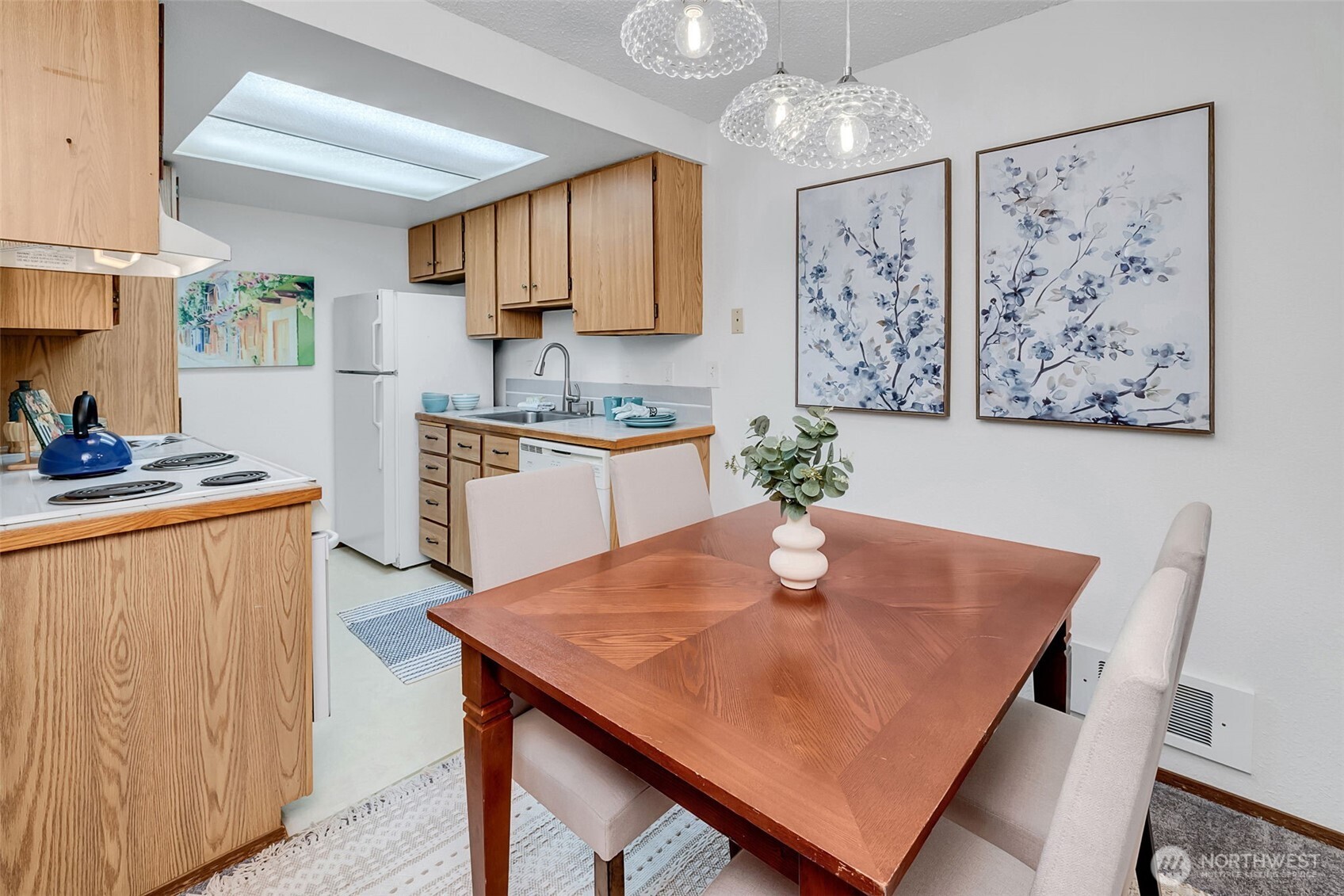 7520 208th Street Southwest, Unit A101 Edmonds, WA 98026 - Photo 13 of 27 a kitchen with a table chairs sink and cabinets