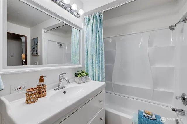 a bathroom with a sink vanity tub and shower