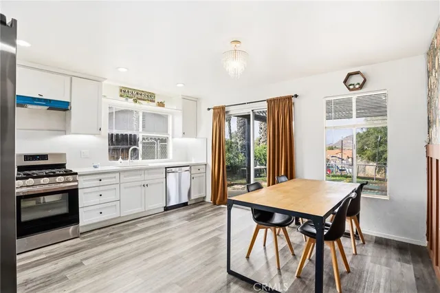 a kitchen with a table chairs stove and wooden floor