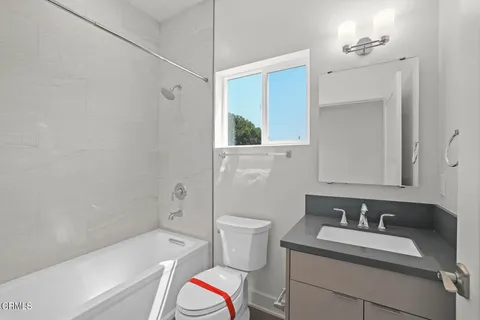 a bathroom with a granite countertop sink a toilet and shower